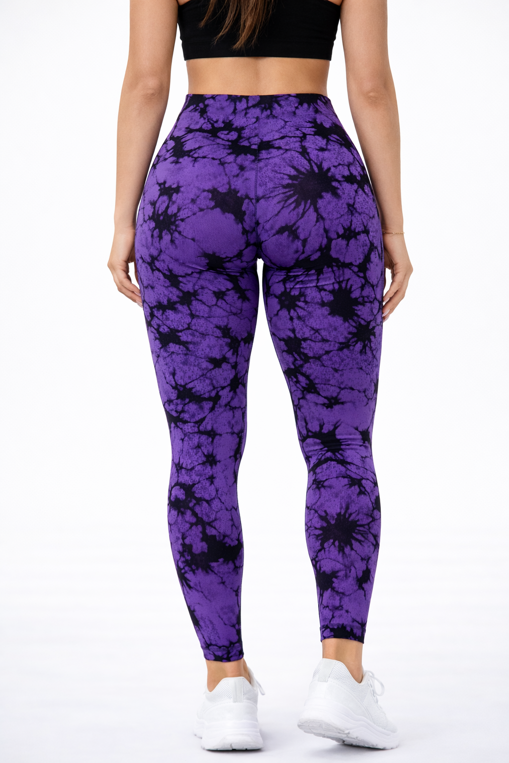 Person wearing purple tie-dye leggings on a white background