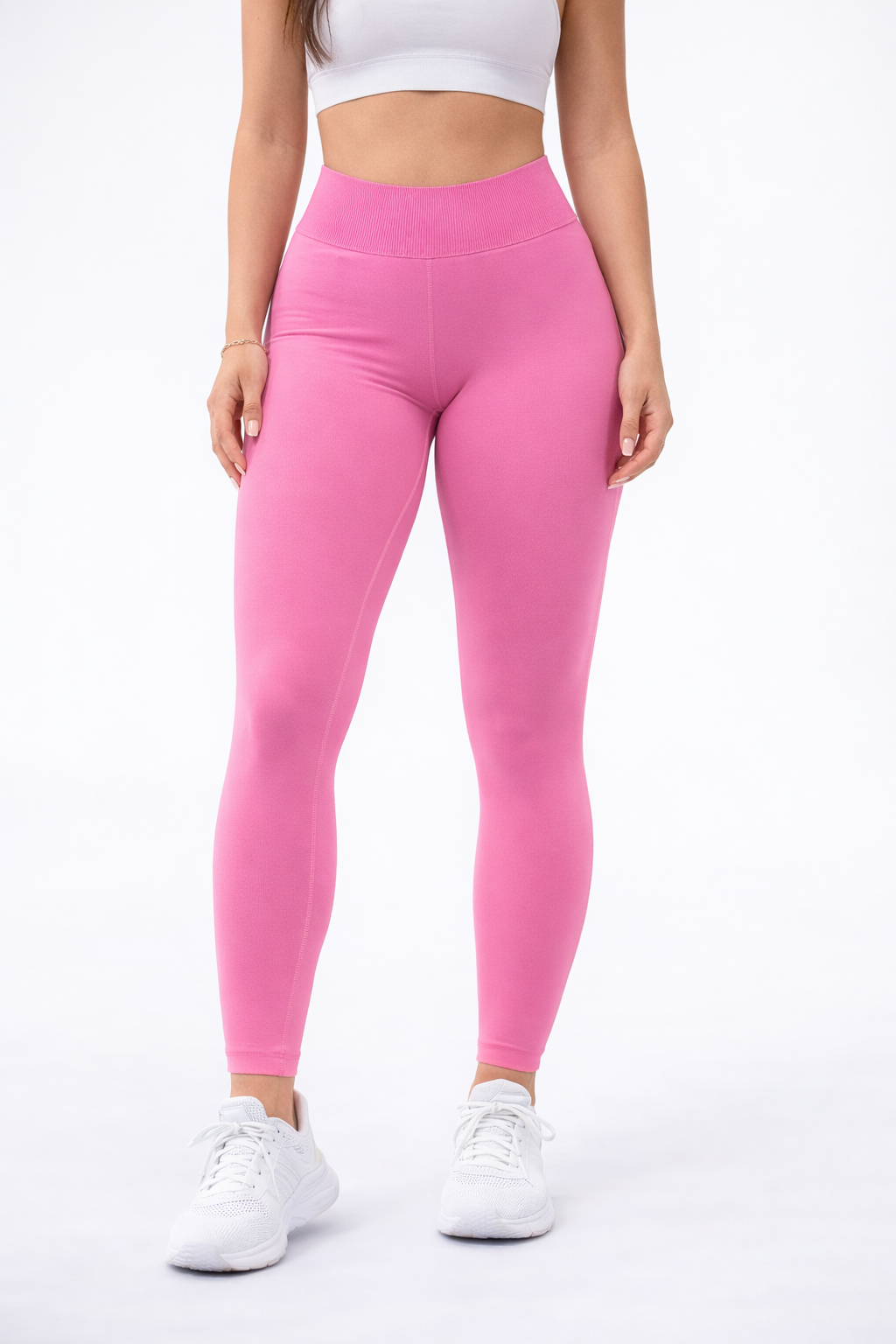 woman wearing pink leggings and white sneakers on a white background